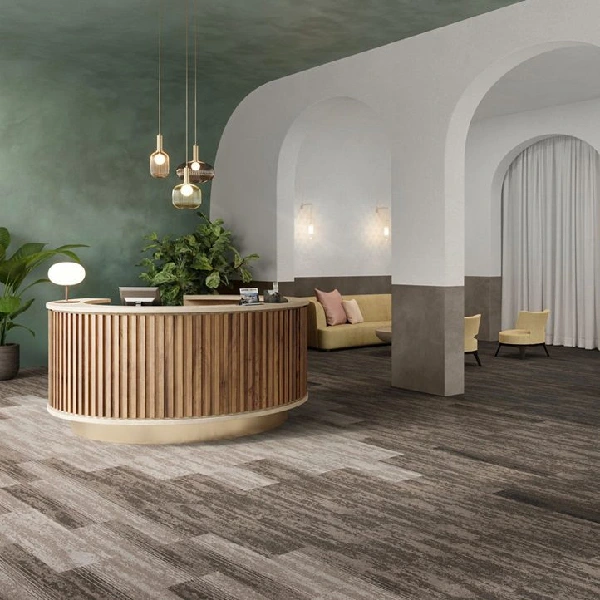 Modern hotel lobby with wood-look carpet tiles and curved reception desk.