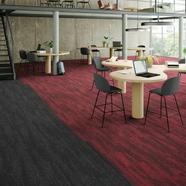 Modern office space with burgundy carpet tiles and collaborative workspace