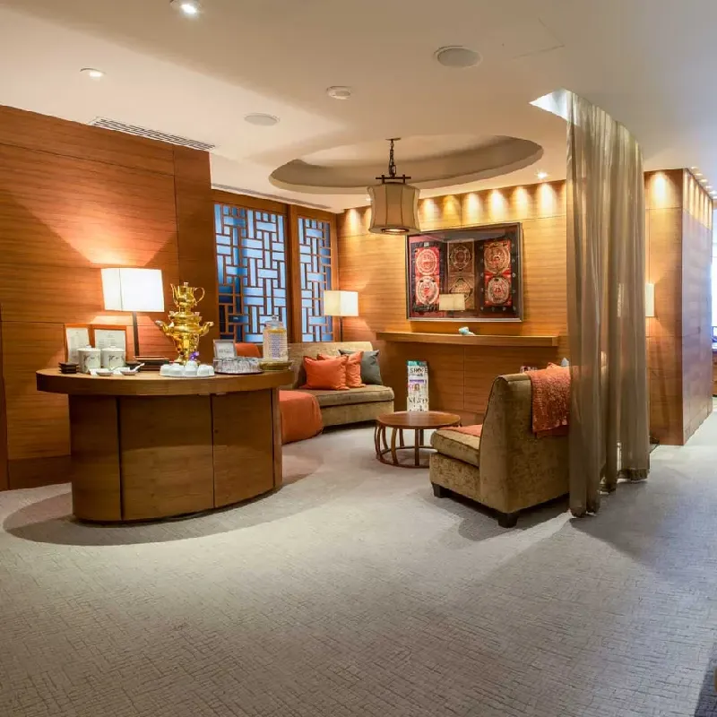 subtly patterned wall-to-wall carpet in a warm, wood-paneled lounge.